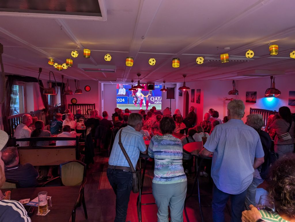 Public Viewing zur EM 2024, der Saal in rotes Licht getaucht