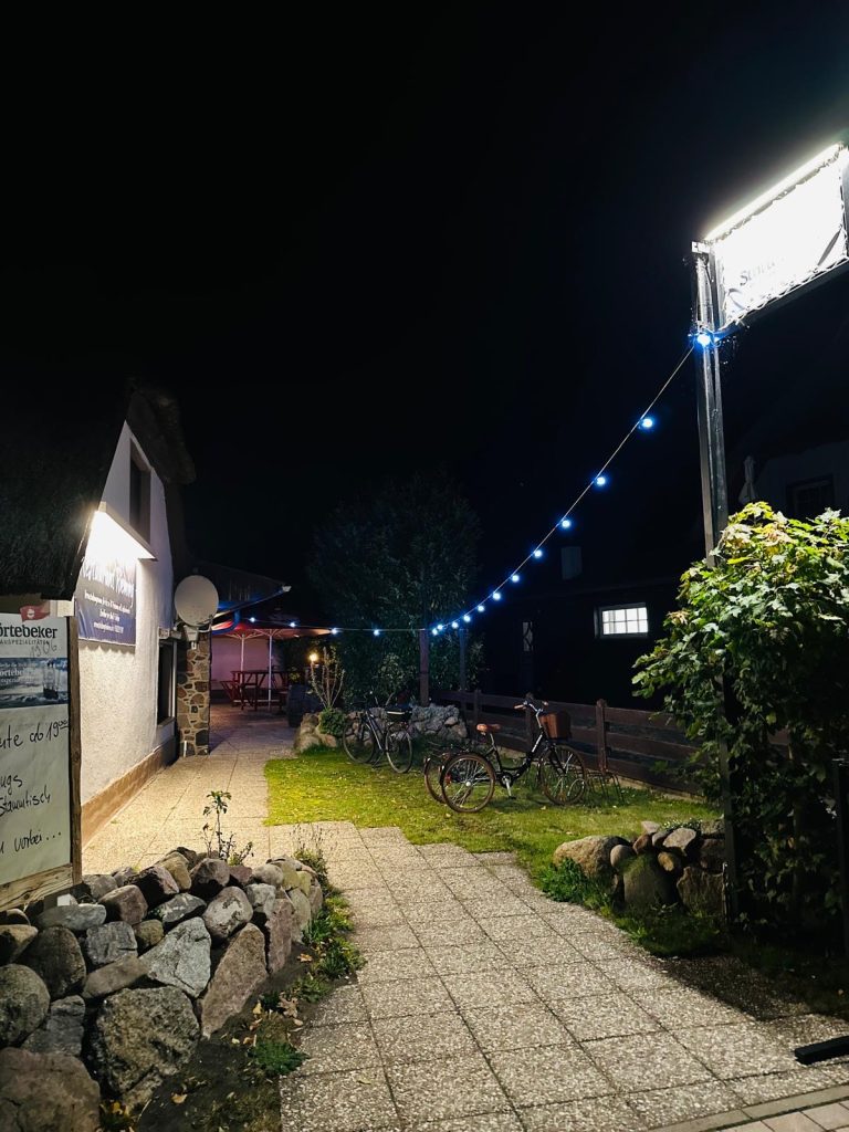 Weg zum Haus bei Nacht mit Lichterkette und Fahrrädern